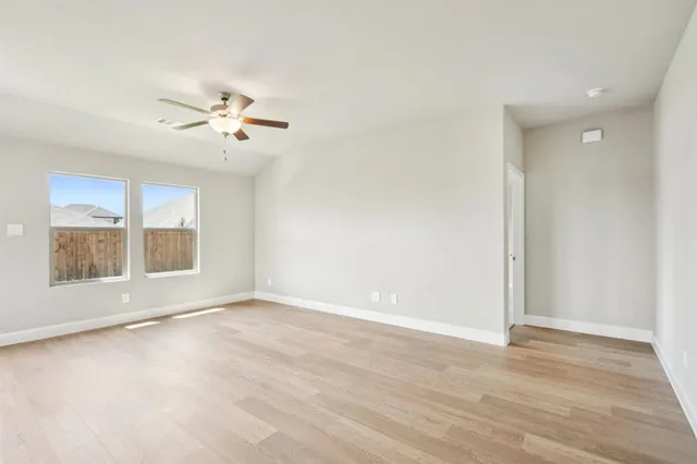 a view of an empty room with a window and bathroom
