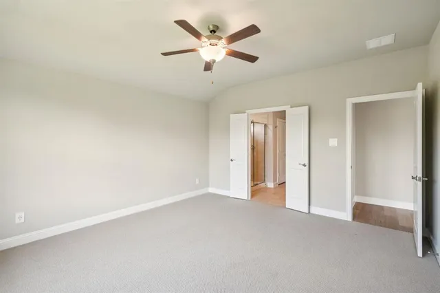 an empty room with closet and ceiling fan