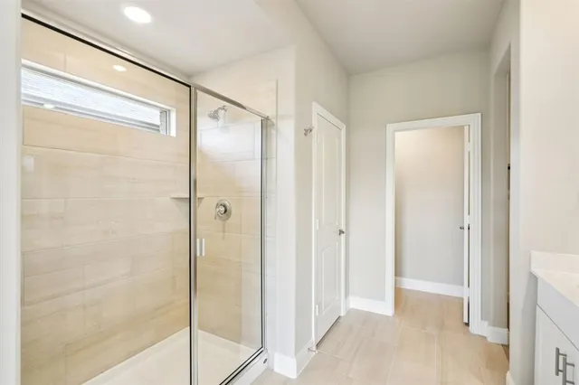 a bathroom with a shower and a glass door