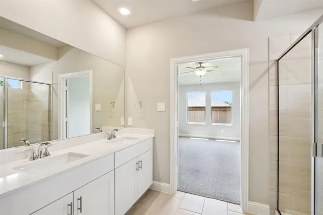 a bathroom with a double vanity sink mirror and shower