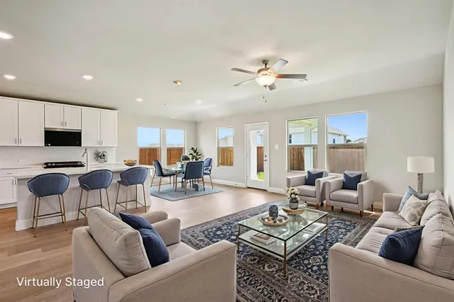 a view of an empty room with a kitchen and wooden floor