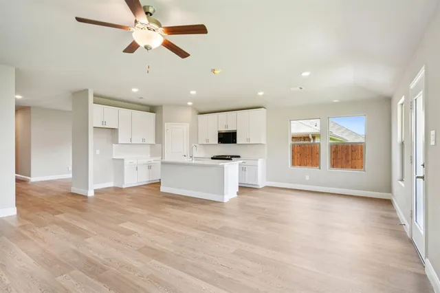 a living room with furniture and a view of kitchen