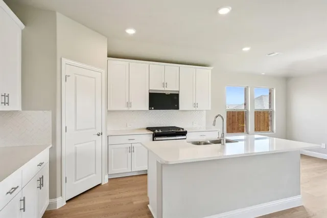 a kitchen with granite countertop a stove and a microwave