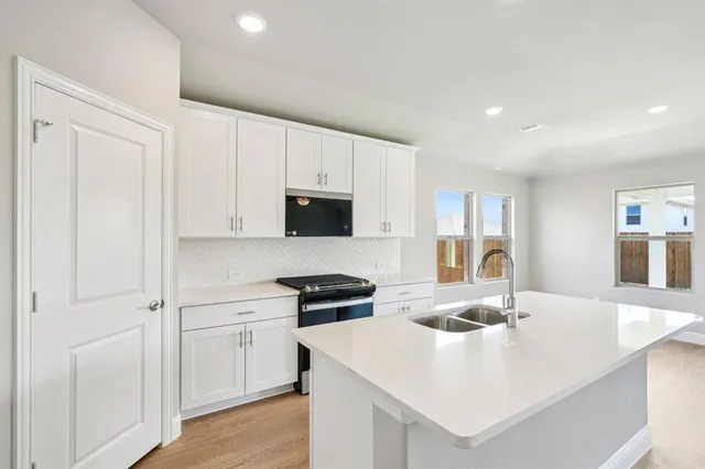 a kitchen with stainless steel appliances a stove refrigerator sink and cabinets