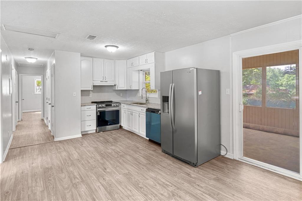4776 Duncan Drive Powder Springs, GA 30127 - Photo 8 of 24 a kitchen with stainless steel appliances granite countertop a refrigerator and a stove top oven
