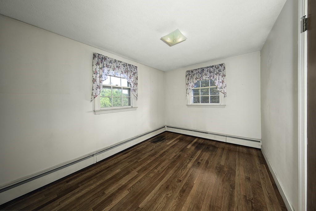 7 Rand Road Salem, MA 01970 - Photo 19 of 24 an empty room with wooden floor and windows