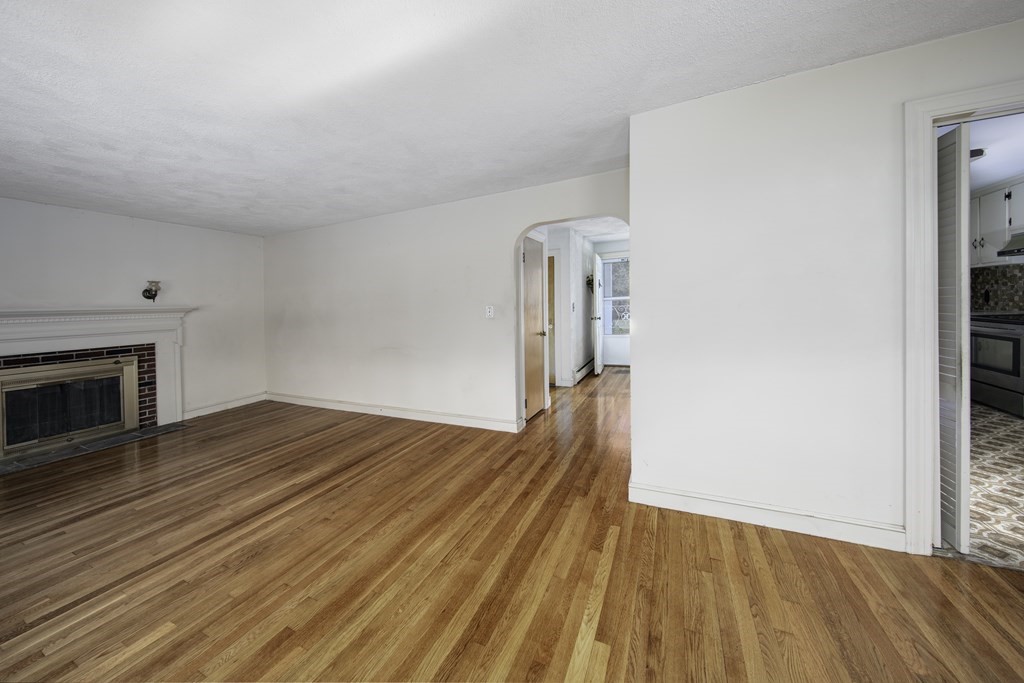 7 Rand Road Salem, MA 01970 - Photo 9 of 24 a view of empty room with wooden floor and fireplace