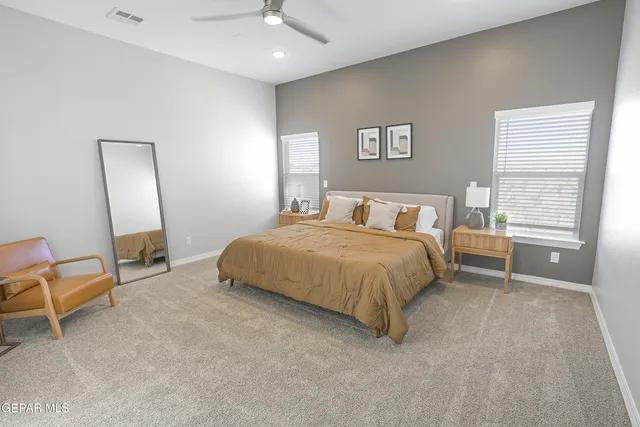 a bedroom with a bed a chair and a large mirror