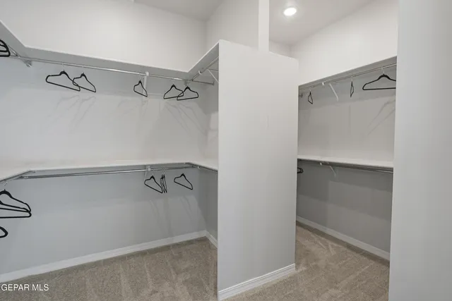 a view of walk in closet with empty racks