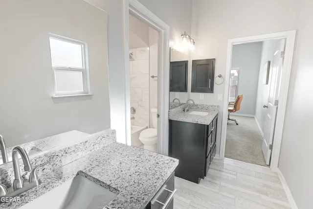 a spacious bathroom with a granite countertop sink and a mirror