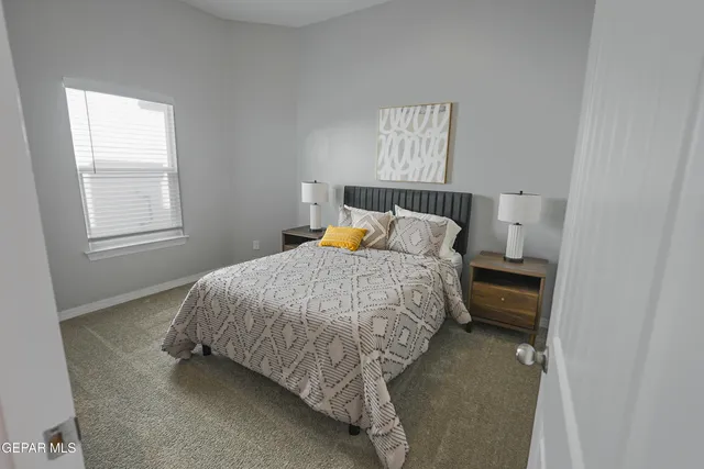 a bed sitting in a bedroom next to a window