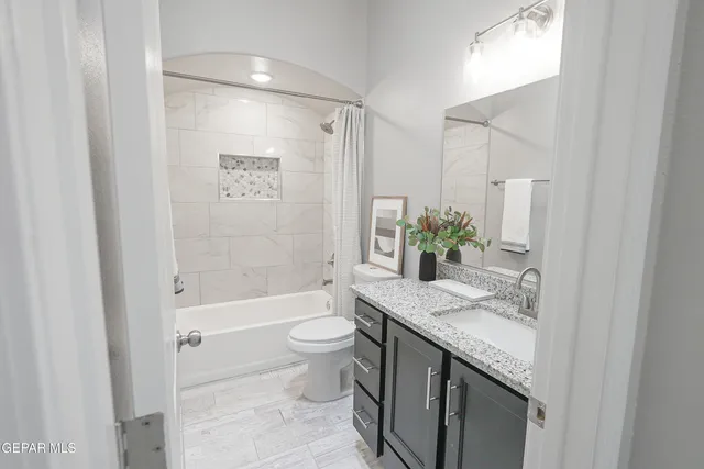a bathroom with a granite countertop sink toilet and shower