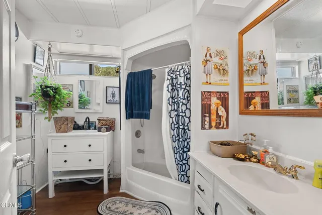 a bathroom with a tub shower sink and cabinets