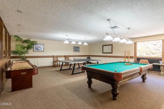 a room with pool table and windows