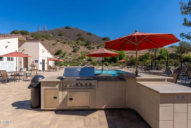 a view of a patio with a table and chairs under an umbrella