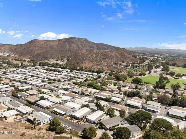 an aerial view of residential houses with outdoor space and trees