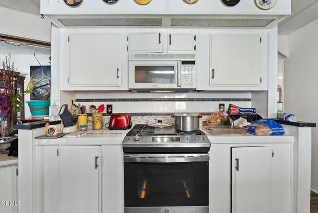 a kitchen with a stove a sink and cabinets
