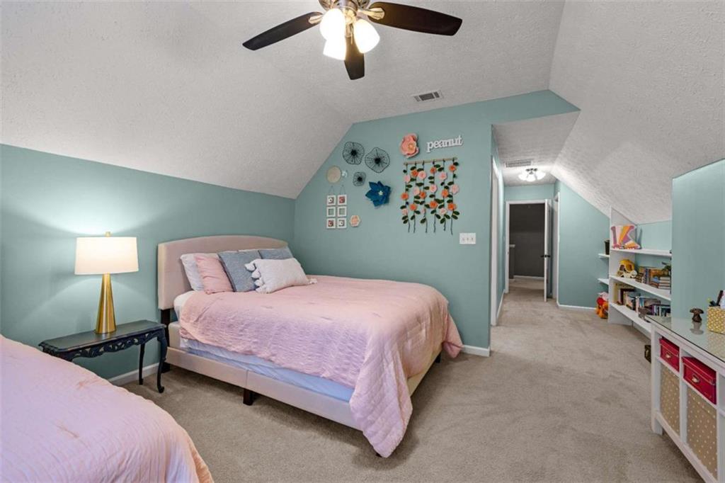 128 Byrom Road Senoia, GA 30276 - Photo 43 of 83 a bedroom with a bed and a chandelier
