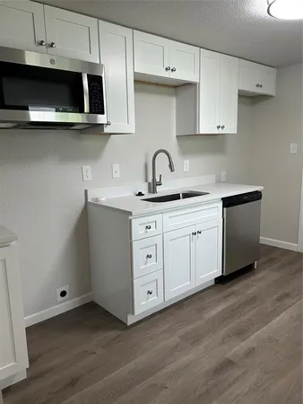 a kitchen with stainless steel appliances granite countertop a sink a stove a microwave and cabinets