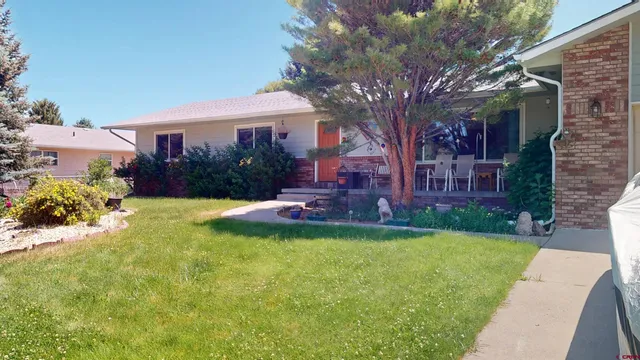 a view of a house with a yard and pathway
