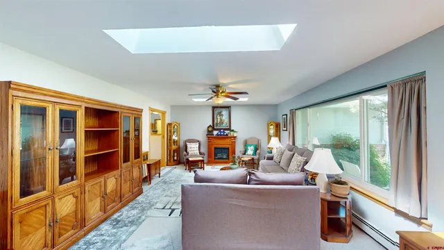 a living room with furniture a flat screen tv and a floor to ceiling window