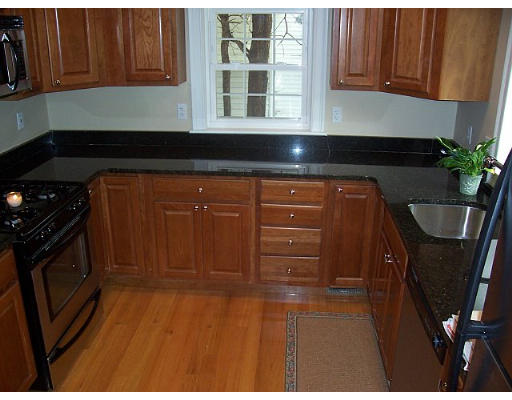 31 Harding Road Lexington, MA 02420 - Photo 6 of 16 a kitchen with granite countertop wood cabinets and black appliances