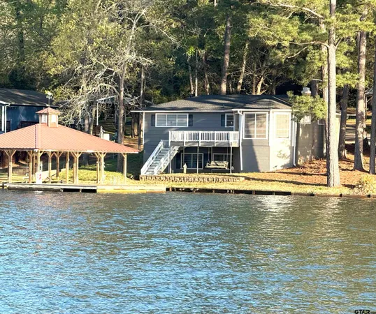 a view of a swimming pool with lawn chairs under an umbrella