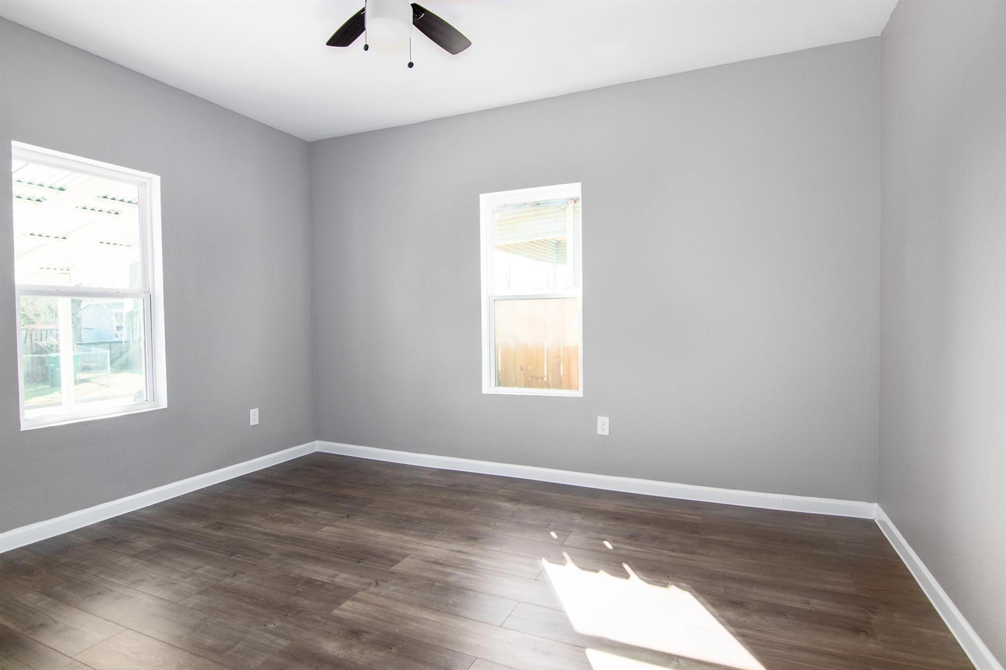 1709 Stevens Street Houston, TX 77026 - Photo 11 of 17 an empty room with wooden floor and windows