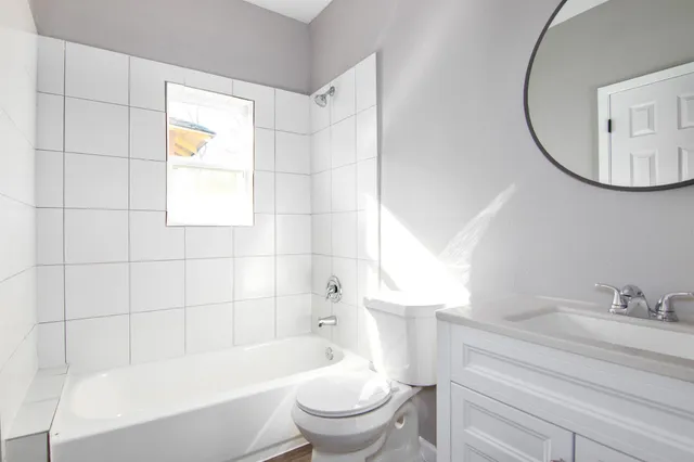 a bathroom with a bathtub a sink a toilet and a mirror