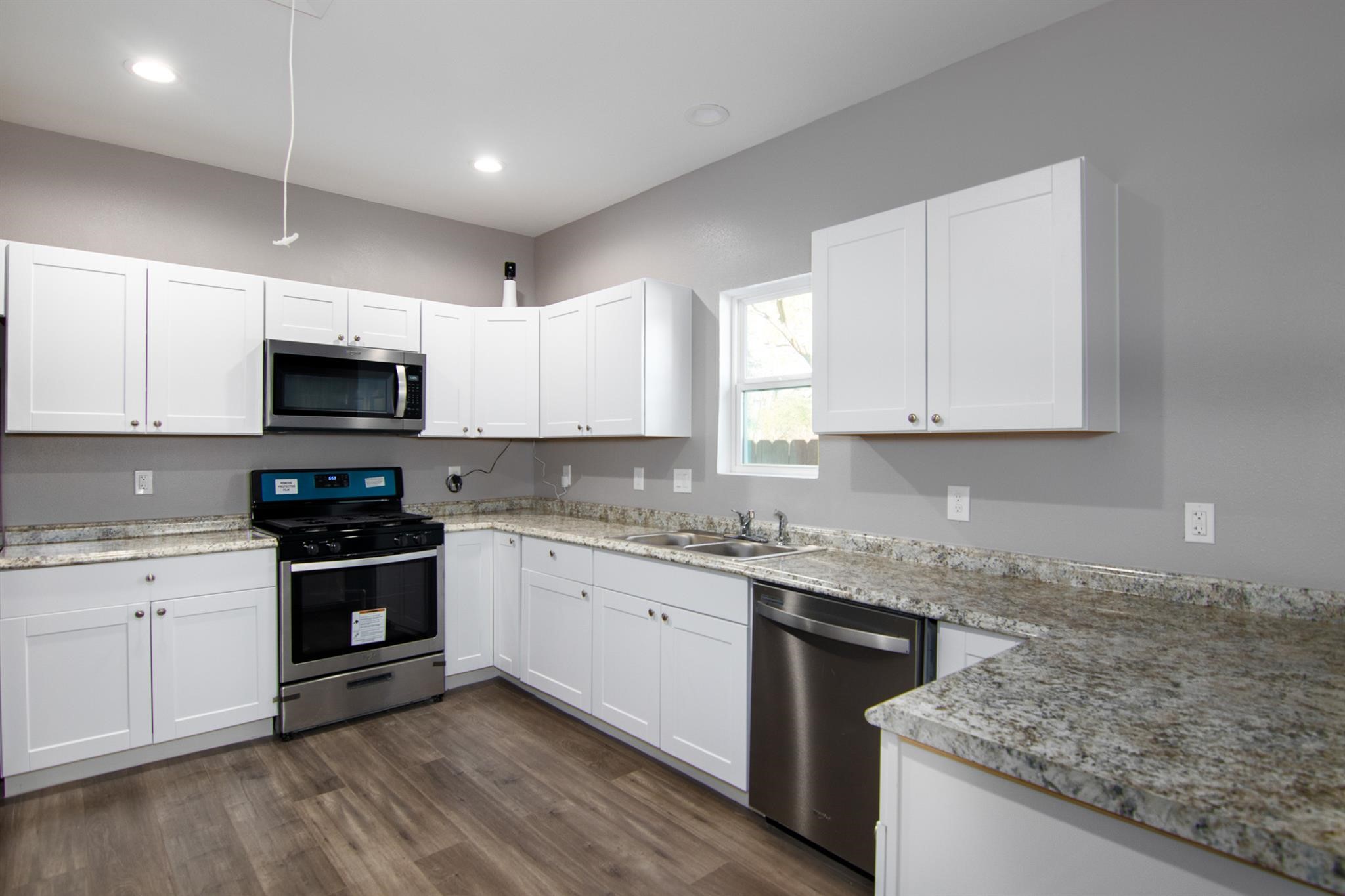 1709 Stevens Street Houston, TX 77026 - Photo 4 of 17 a kitchen with granite countertop a stove top oven sink and cabinets