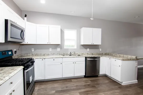 a kitchen with granite countertop cabinets stainless steel appliances and a sink