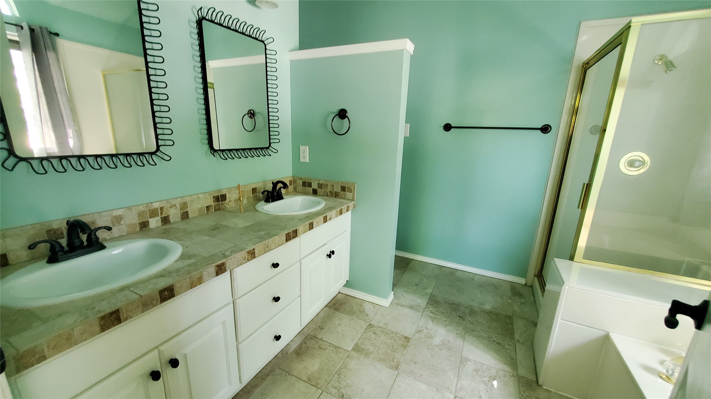 201 Rio Vista Drive Georgetown, TX 78626 - Photo 14 of 26 Dual vanity sinks with tile countertops and a glass-enclosed shower create a functional bathroom space.