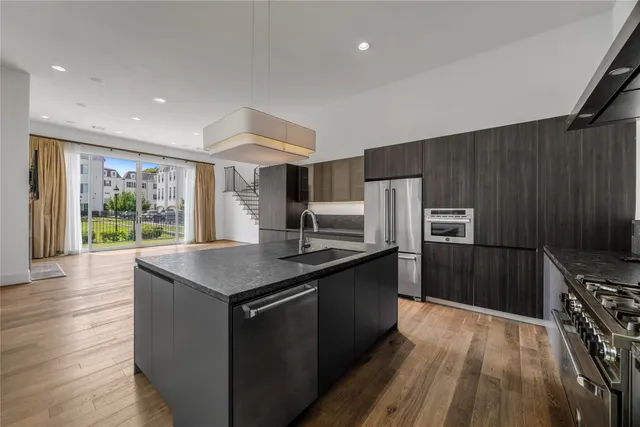 a kitchen with stainless steel appliances granite countertop a sink stove and refrigerator