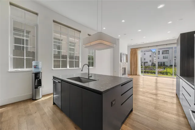 a kitchen with stainless steel appliances granite countertop a sink and a large window