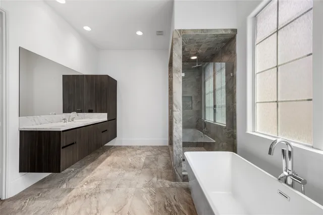a bathroom with a bathtub sink and mirror