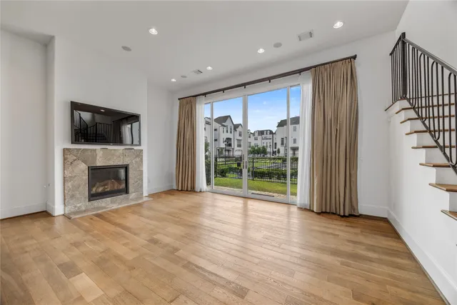 a view of an empty room with a fireplace and a window