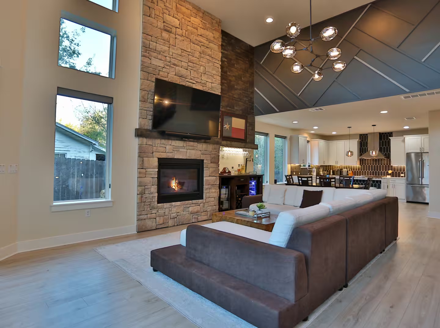 2203 Thornton Road, Unit A Austin, TX 78704 - Photo 6 of 22 Living room featuring light wood-style flooring, a stone fireplace, lofted ceiling, and suspended lighting