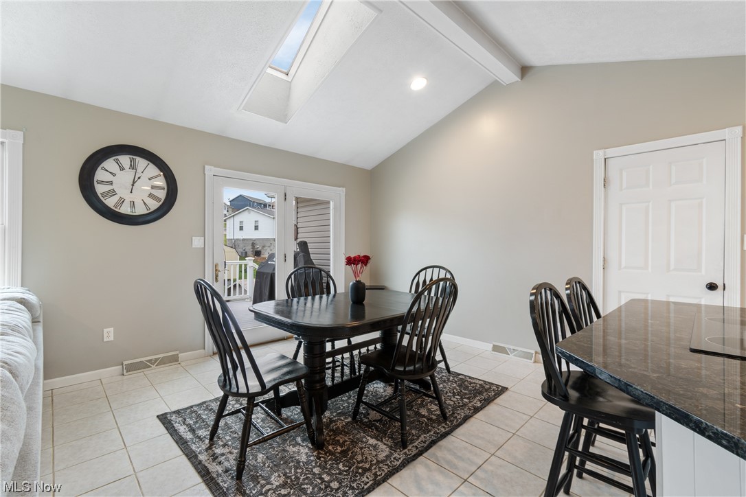 53330 High Ridge Road Bridgeport, OH 43912 - Photo 12 of 34 Dining room featuring light tile floors and vaulted ceiling with skylight