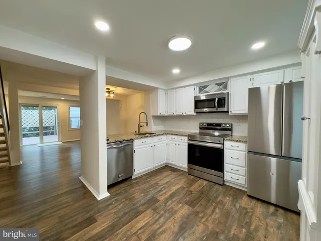 a kitchen with stainless steel appliances granite countertop a refrigerator stove top oven and sink