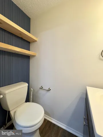 a white toilet sitting next to a white wall