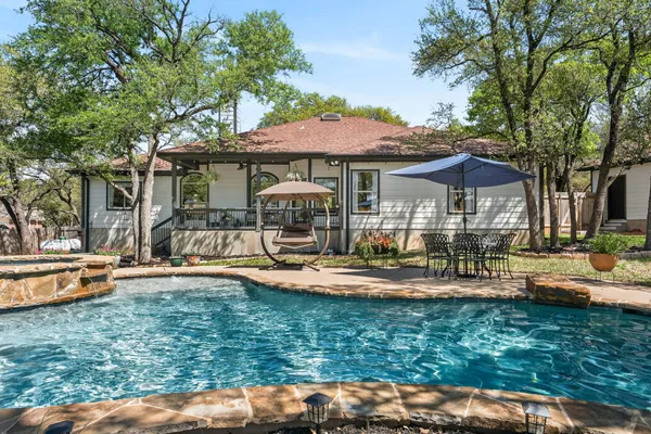 a front view of a house with swimming pool garden and patio