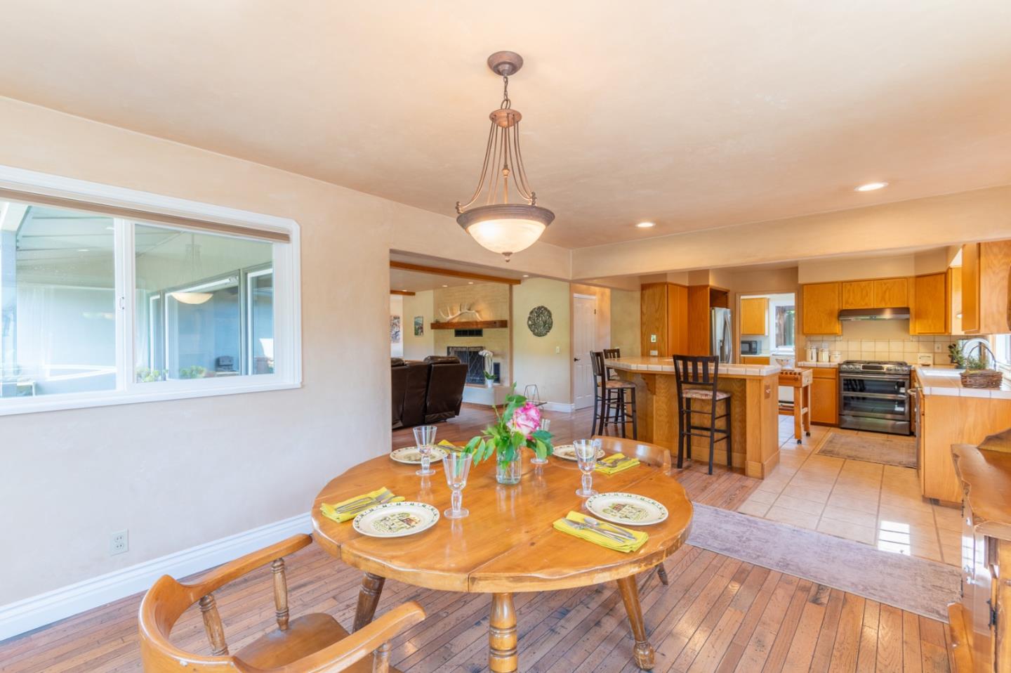 2 Merrill Way Carmel Valley, CA 93924 - Photo 16 of 43 a dining room with wooden floor a chandelier a wooden table and chairs