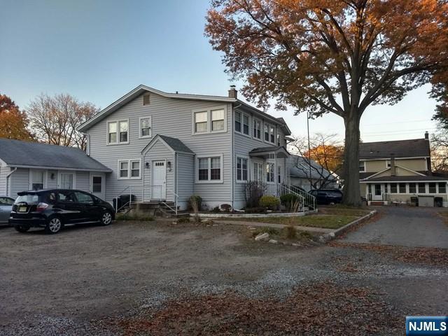 192 West Midland Avenue, Unit 1 Paramus, NJ 07652 - Photo 14 of 14 a view of a white house next to a yard with big trees