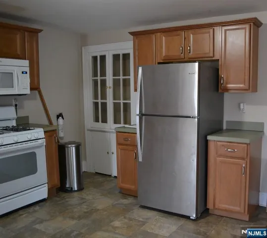 a white refrigerator freezer and a stove sitting inside of a kitchen