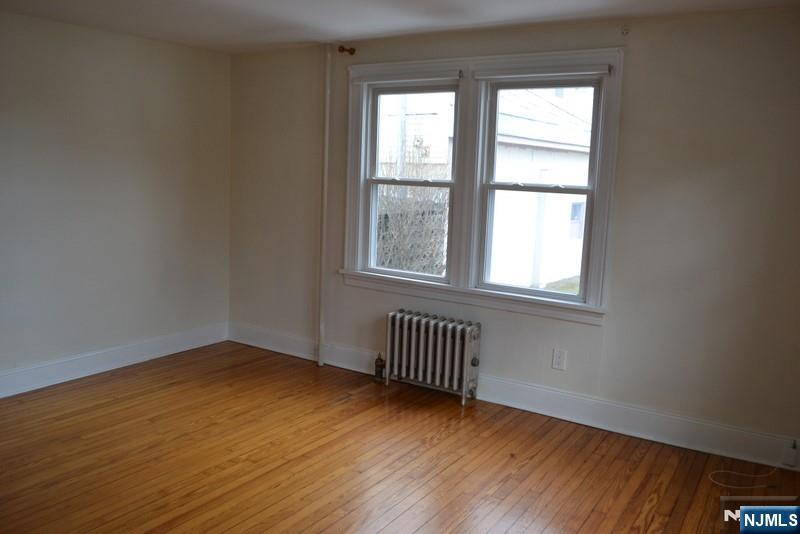 192 West Midland Avenue, Unit 1 Paramus, NJ 07652 - Photo 10 of 14 an empty room with wooden floor and windows