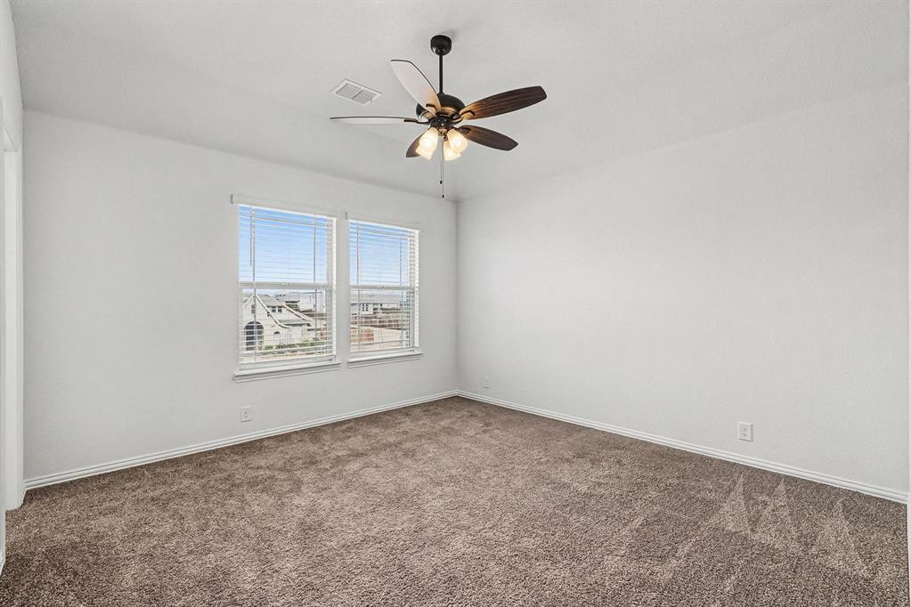 1080 Canuela Way Justin, TX 76247 - Photo 29 of 40 an empty room with window and ceiling fan