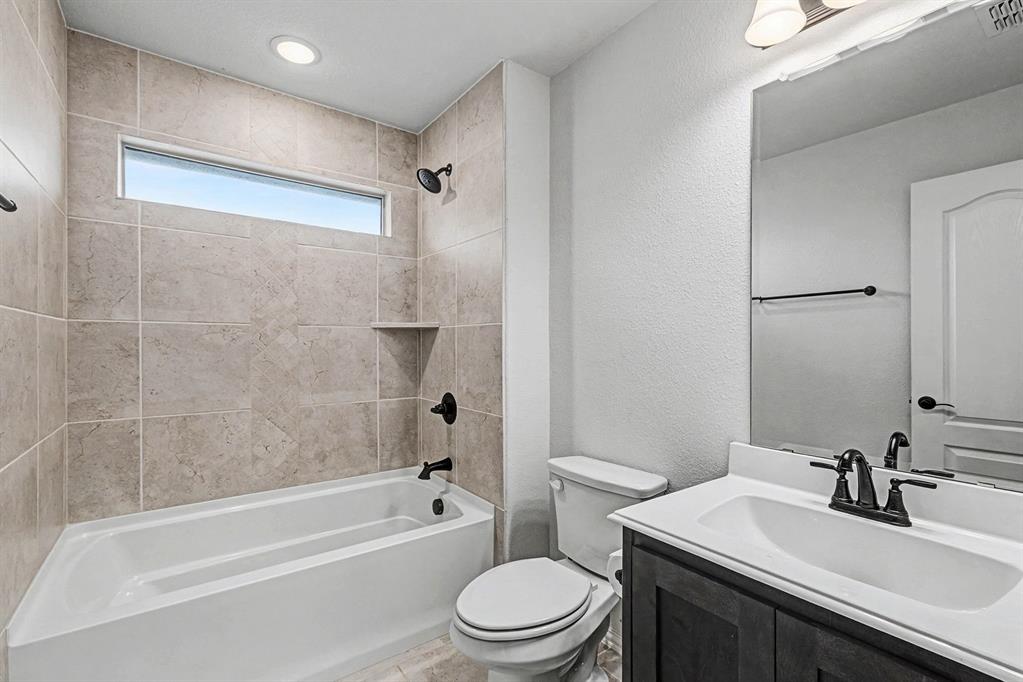 1080 Canuela Way Justin, TX 76247 - Photo 30 of 40 a bathroom with a bathtub shower sink vanity mirror and toilet