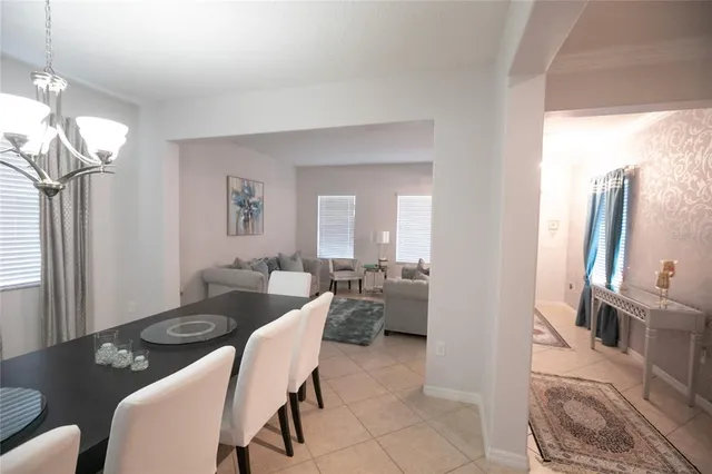 a view of a dining room with furniture a chandelier and wooden floor