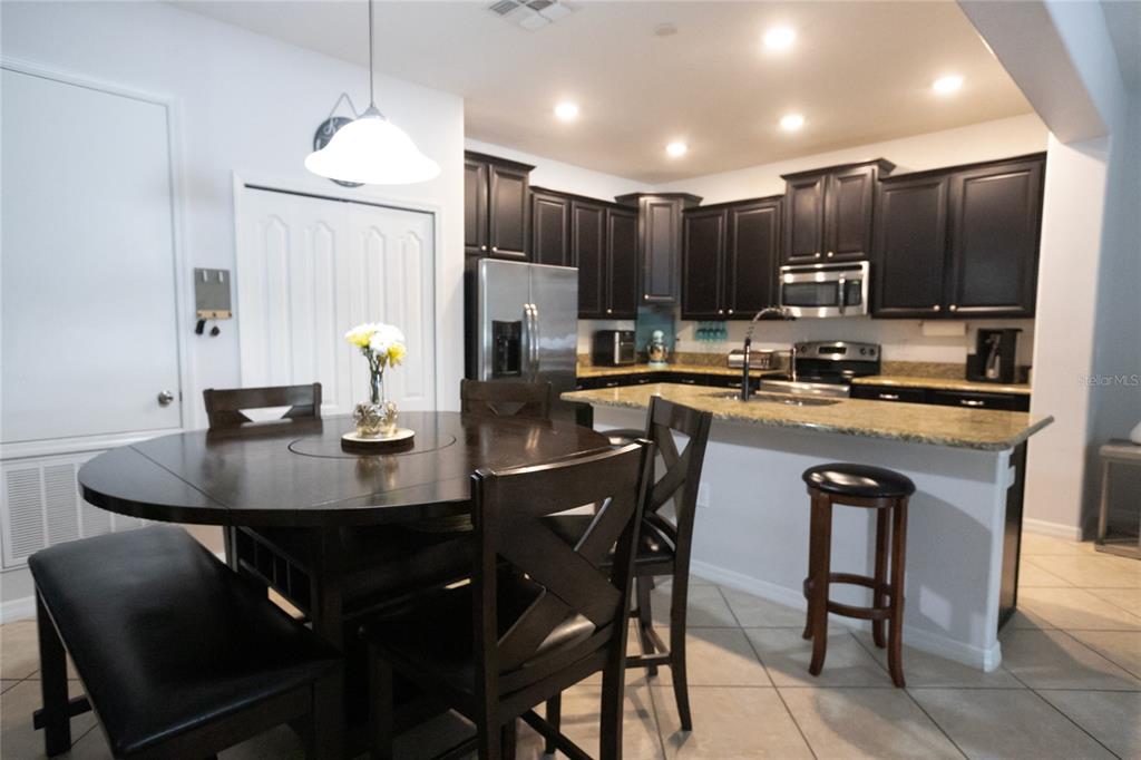 1185 Seburn Road Apopka, FL 32703 - Photo 15 of 47 a kitchen with a dining table chairs and refrigerator
