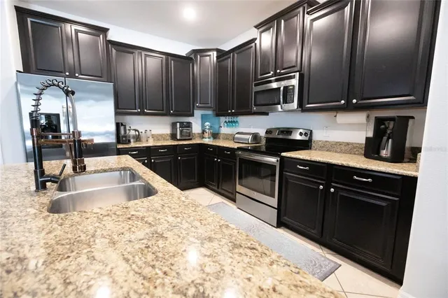 a kitchen with stainless steel appliances granite countertop a sink stove and refrigerator